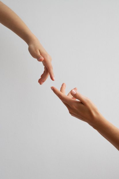 Photo of two hands nearly touching, both showcasing beautifully styled and perfect nails.