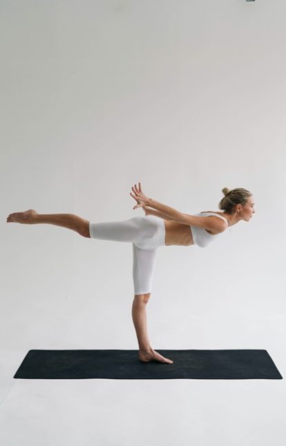 A woman engaging in fitness classes as part of her self-care routine, performing exercises with dedication and focus.