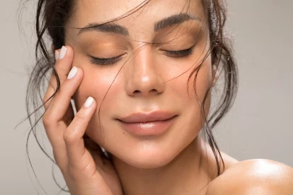The image depicts a contented woman, showcasing her manicured and pedicured nails, emphasizing self-care.