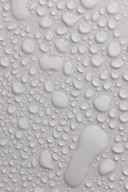 Close-up of water droplets on a white surface.
